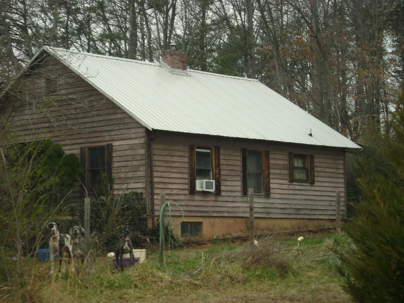 White metal roof on an old wood sided farmhouse, from a Metal Roof Installation job in Saint Albans