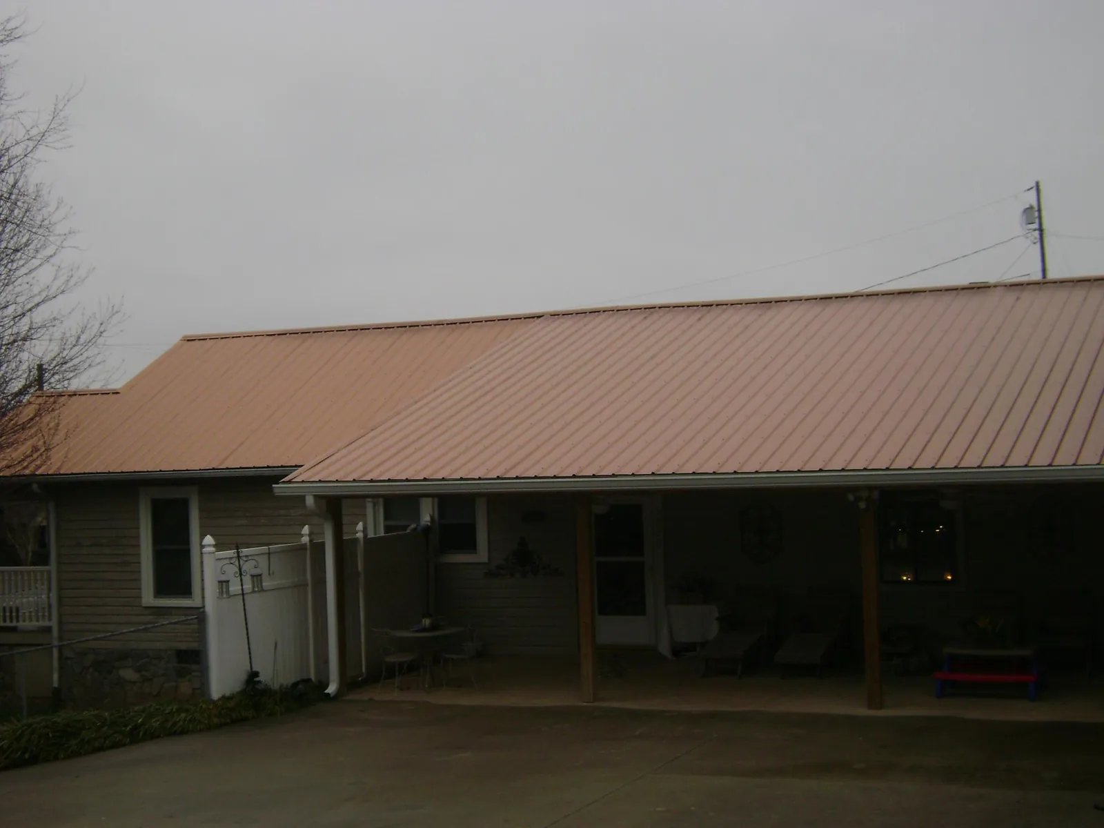 Copper toned metal roof over a wide covered patio in Saint Albans